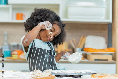 Fotografía african afro black daughter kids sifting flour powder and sprinkling ingredients on massaging dough for bakery cooking