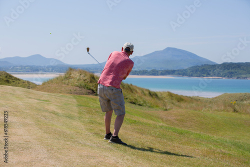 Man playing golf by the sea in ireland.