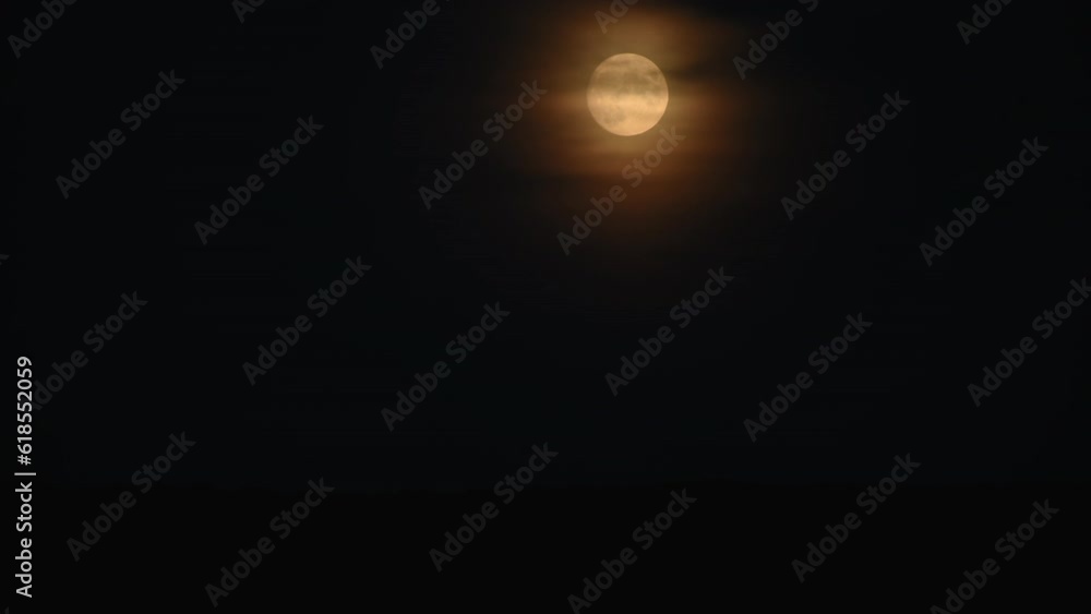 Yellow full moon rises in black sky in the night. Fast shooting. Rapide moonrise. Pink full moon Yellow full moon rises in black sky in the night. Fast shooting. Rapide moonrise. Pink full moon