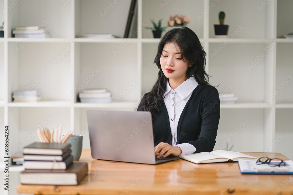 A portrait of a smiling, young, beautiful, professional, and confident millennial caucasian businesswoman using a digital tablet to analyze sales data at a modern office. A portrait of a smiling, young, beautiful, professional, and confident millennial caucasian businesswoman using a digital tablet to analyze sales data at a modern office.