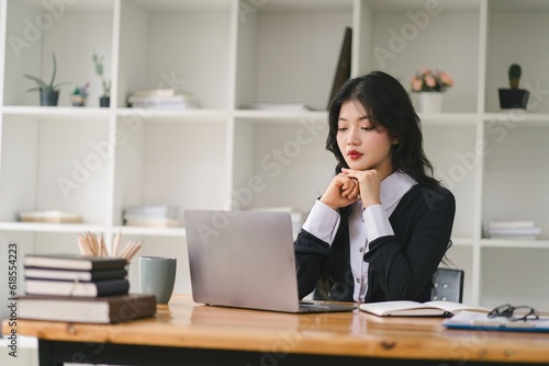 A portrait of a smiling, young, beautiful, professional, and confident millennial caucasian businesswoman using a digital tablet to analyze sales data at a modern office.