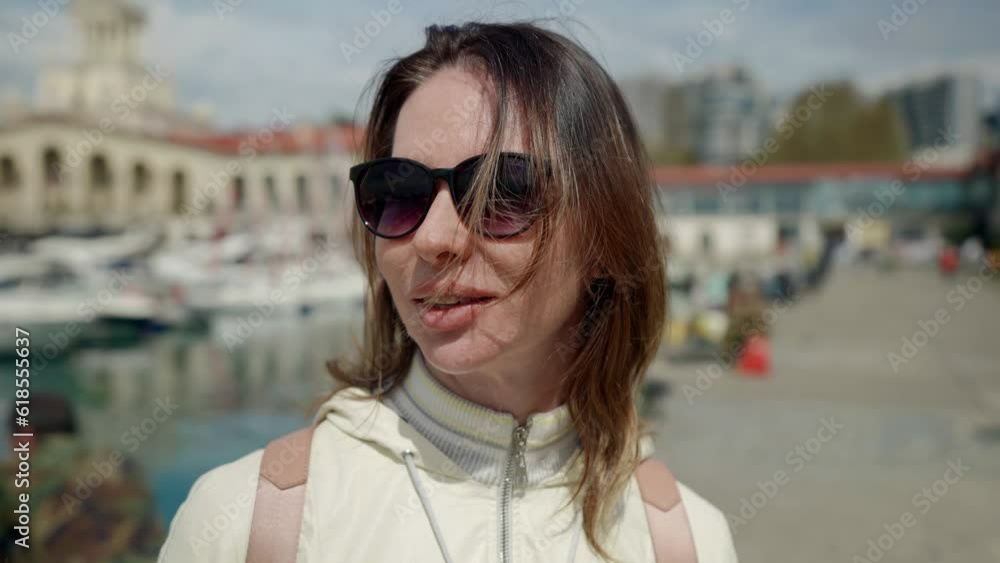 charming female tourist smiling and walking in small harbor of touristic city near sea, summer trip charming female tourist smiling and walking in small harbor of touristic city near sea, summer trip