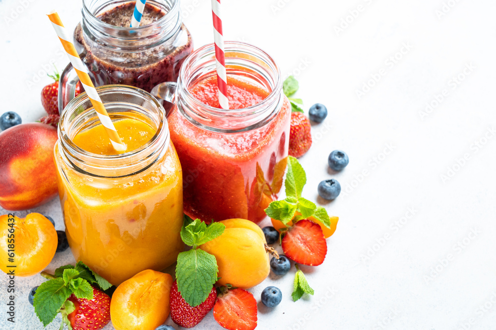 Smoothie set with fresh fruits and berries at white background. Homemade healthy drink. Smoothie set with fresh fruits and berries at white background. Homemade healthy drink.