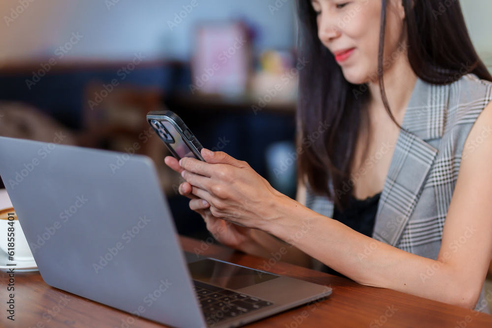 Close-up hand holding phone moves upward until it stops on mouth asian woman sitting talking friend on phone having video call, there is headphone cable that plugs into phone listen with friends. Close-up hand holding phone moves upward until it stops on mouth asian woman sitting talking friend on phone having video call, there is headphone cable that plugs into phone listen with friends.