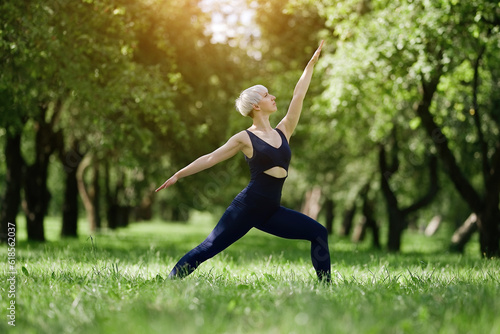 Young woman doing yoga exercise outdoor in the park, sport yoga concept 