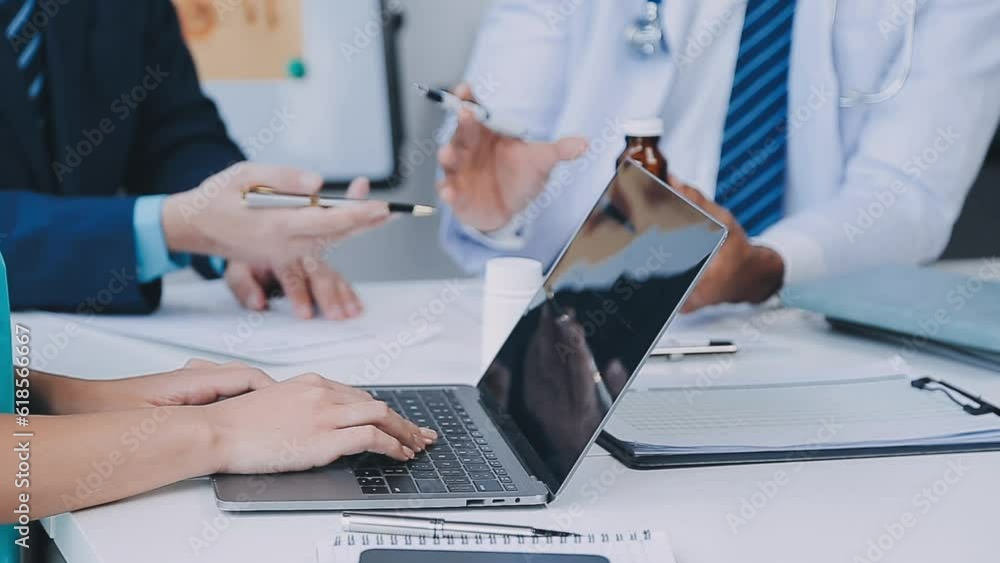 Group of healthcare workers and businessman using laptop while having a meeting in the office. Focus is on young doctor. Group of healthcare workers and businessman using laptop while having a meeting in the office. Focus is on young doctor.