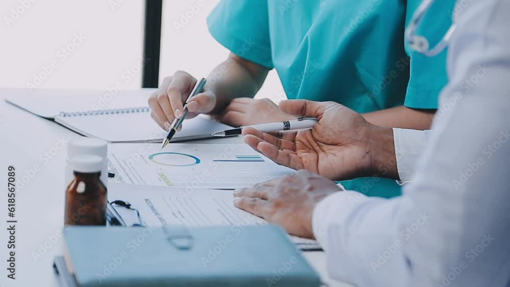 Group of healthcare workers and businessman using laptop while having a meeting in the office. Focus is on young doctor. Group of healthcare workers and businessman using laptop while having a meeting in the office. Focus is on young doctor.