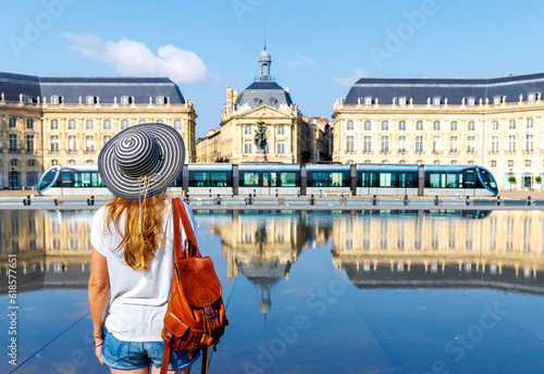 Rear view of woman looking at water mirror on bourse square in Bordeaux- France