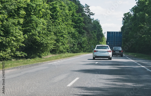 Two cars overtake a truck