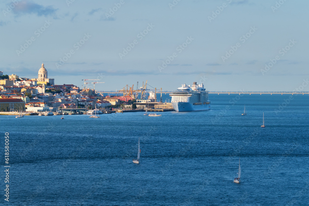 View of Lisbon over Tagus river from Almada with yachts tourist boats and moored cruise liner on sunset. Lisbon, Portugal
