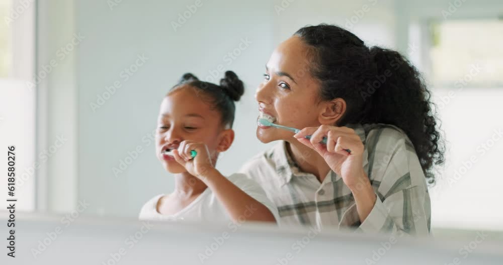 Brushing teeth, mother and daughter in mirror, bathroom and cleaning mouth for wellness, health and self care. Mom, girl child and toothbrush in family house with oral hygiene, smile and teaching Brushing teeth, mother and daughter in mirror, bathroom and cleaning mouth for wellness, health and self care. Mom, girl child and toothbrush in family house with oral hygiene, smile and teaching