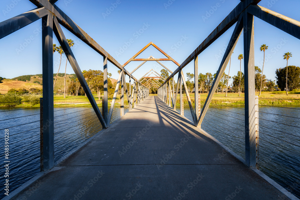 Metal construction pedestrian bridge over the river in a bright sunny day bridge over the river in a bright sunny day Metal construction pedestrian bridge over the river in a bright sunny day bridge over the river in a bright sunny day