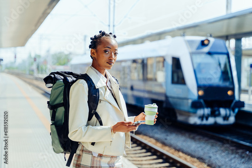woman traveler with backpack in the railway, Backpack and hat at the train station with a traveler, Travel concept. Woman traveler tourist walking at train station