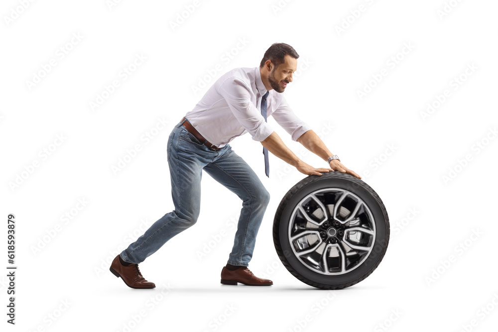 Obraz premium Man pushing a car tire