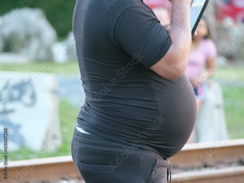 A man with a distended belly in black clothes