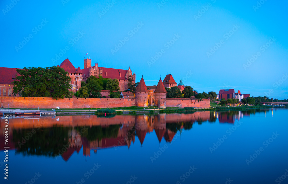 Fototapeta premium Marienburg castle the largest medieval brick castle in the world in the city of Malbork evening view at night