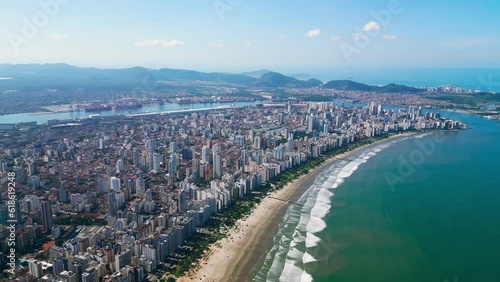 Drone view of the entire island of Santos bathed by the ocean. Port of Santos in the background. Santos, São Paulo, Brazil.