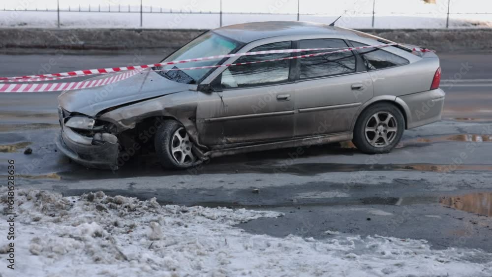 After collision, impacted front, warning tape. Vehicle with smashed front section following accident fenced off by caution tape. After collision, impacted front, warning tape. Vehicle with smashed front section following accident fenced off by caution tape.