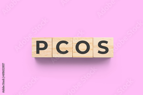PCOS (Polycystic Ovary Syndrome) wooden cubes on pink background