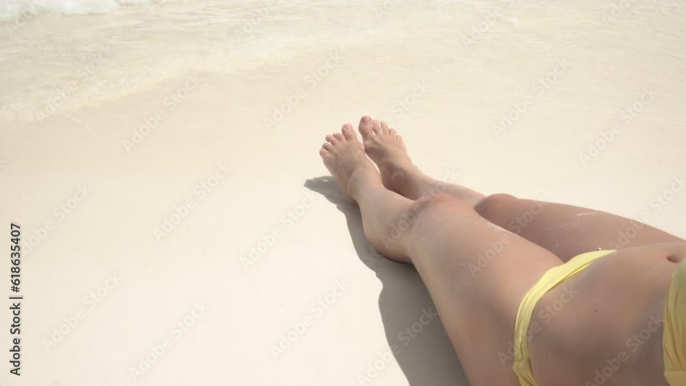A young woman is sunbathing on a beach with white sand and clear water. A beautiful woman is resting in the Maldives A young woman is sunbathing on a beach with white sand and clear water. A beautiful woman is resting in the Maldives