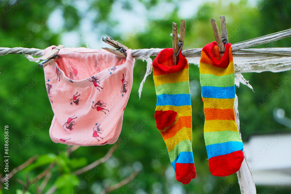 female underwear and socks air drying on the clothes line outside in
