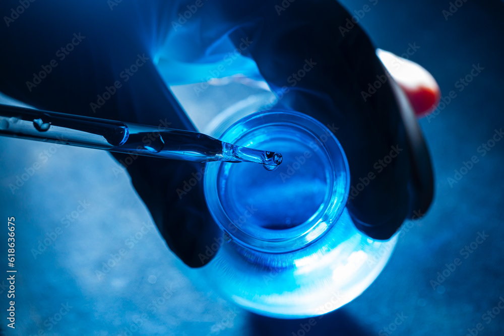 Blue science test tube,Flask in scientist hand with drop of chemical liquid in test tube Science and medical research and development concepts. Blue science test tube,Flask in scientist hand with drop of chemical liquid in test tube Science and medical research and development concepts.