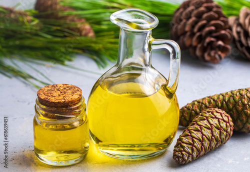 Pine turpentine essential oil in glass bottle with pine coniferous leaves and pine cone. Kiefer turpentin photo