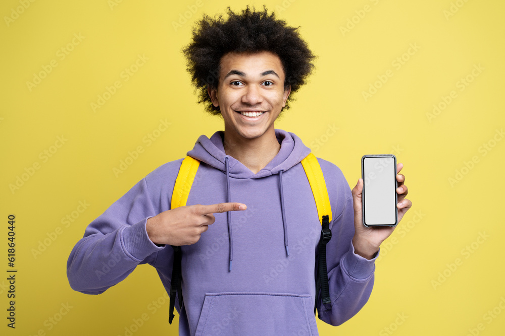 Amazed african american guy pointing finger, showing to camera smartphone Amazed african american guy pointing finger, showing to camera smartphone