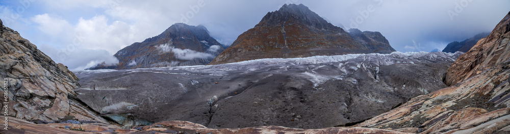 Obraz premium Panoramic photo of the Aletch Glacier in the Swiss Alps. Huge blocks of dirty ice against the backdrop of the mountains Olmenhorn and Gaeisshorn in Switzerland