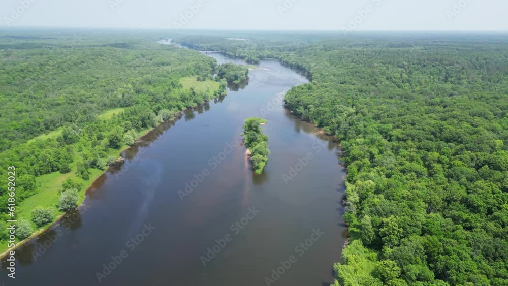 Drone Shot of Beautiful Blue River with an Island and Reflections in the Flowing Water and Trees Along Shoreline with Scenic Green Forest Landscape Panorama