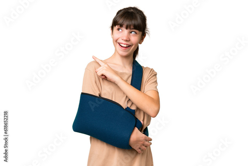 Little caucasian girl with broken arm and wearing a sling over isolated background intending to realizes the solution while lifting a finger up