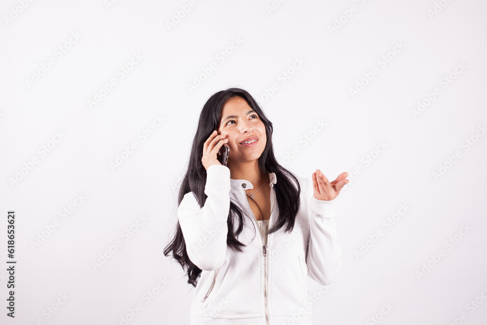 Photograph of young woman talking on the phone on a white studio background. Concept of people. Photograph of young woman talking on the phone on a white studio background. Concept of people.