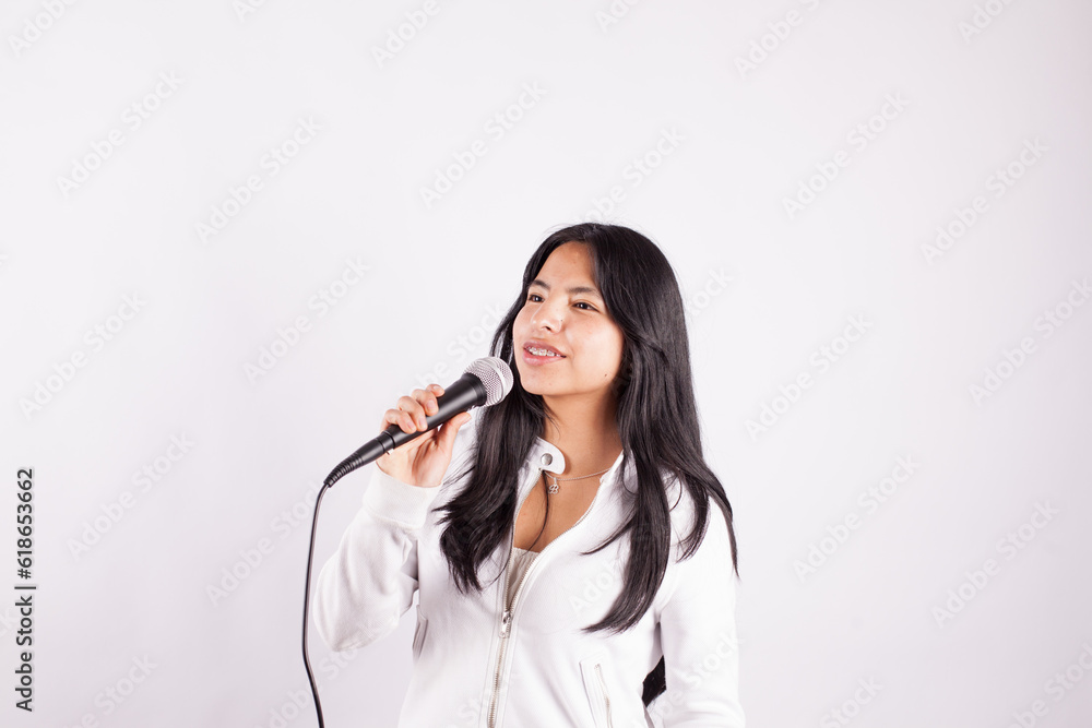 Photograph of young woman singing with a microphone on a white background. Concept of people and hobbies. Photograph of young woman singing with a microphone on a white background. Concept of people and hobbies.