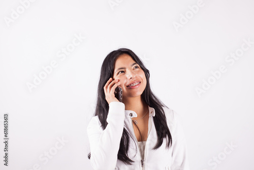 Photograph of young woman talking on the phone on a white studio background. Concept of people.