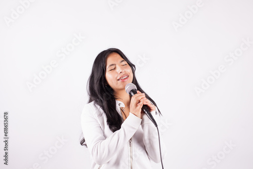 Photograph of young woman singing with a microphone on a white background. Concept of people and hobbies.
