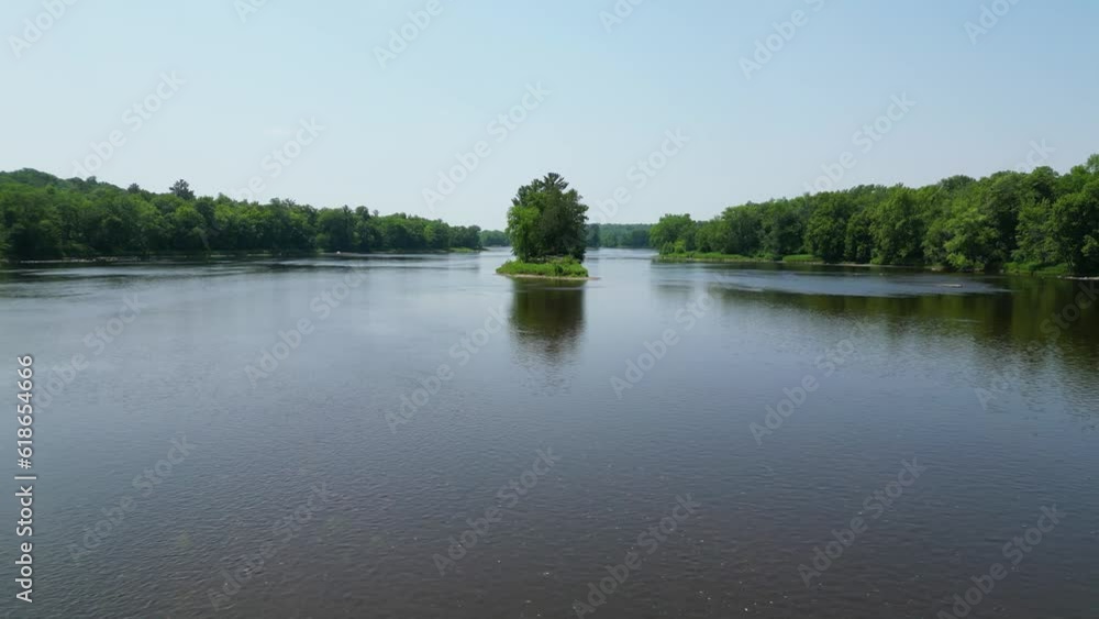 Drone Shot of Beautiful Blue River with an Island and Reflections in the Flowing Water and Trees Along Shoreline with Scenic Green Forest Landscape Panorama Drone Shot of Beautiful Blue River with an Island and Reflections in the Flowing Water and Trees Along Shoreline with Scenic Green Forest Landscape Panorama