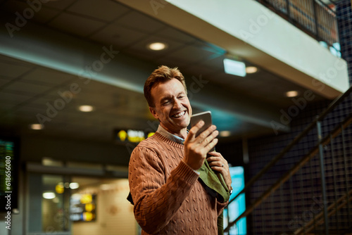 Mature man using a smart phone while waiting at a train station