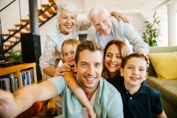 Multigenerational family taking a selfie at home in the living room