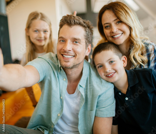 Young family taking a selfie in the living room at home