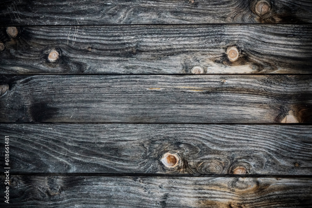 Dark stained reclaimed wood surface with aged boards lined up. Wooden