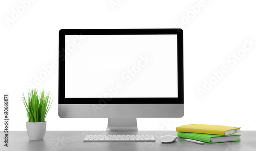 Computer, potted plant and notebooks on table against white background. Stylish workplace