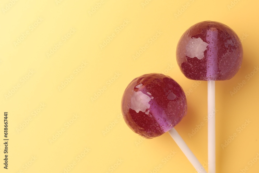 Tasty lollipops on yellow background, flat lay. Space for text Tasty lollipops on yellow background, flat lay. Space for text