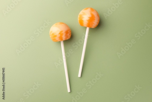 Tasty lollipops on green background, flat lay