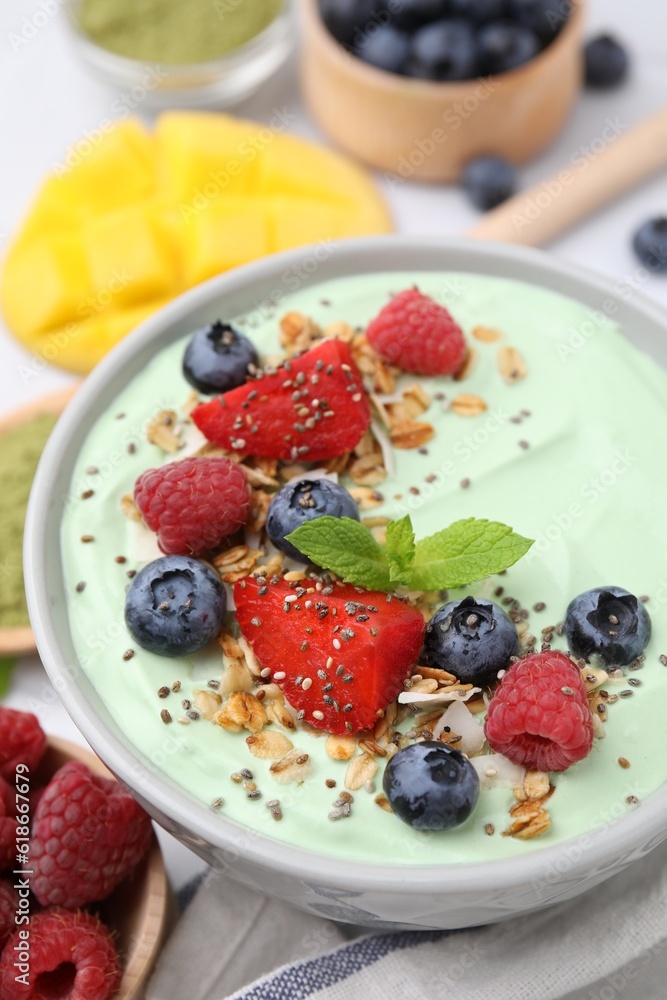 Tasty matcha smoothie bowl served with berries and oatmeal on white table, closeup. Healthy breakfast Tasty matcha smoothie bowl served with berries and oatmeal on white table, closeup. Healthy breakfast