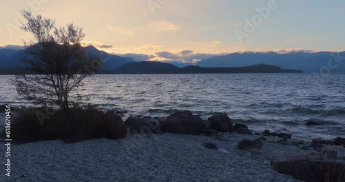 Aerial: wind over Lake at sunset, Manapouri, New Zealand photo