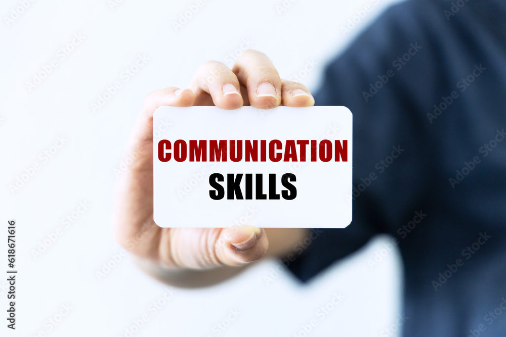 Communication skills text on blank business card being held by a woman's hand with blurred background. Business concept about communication skills. Communication skills text on blank business card being held by a woman's hand with blurred background. Business concept about communication skills.