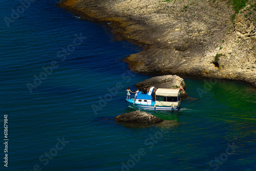 Recreational boat sailing in background of an island in sea
