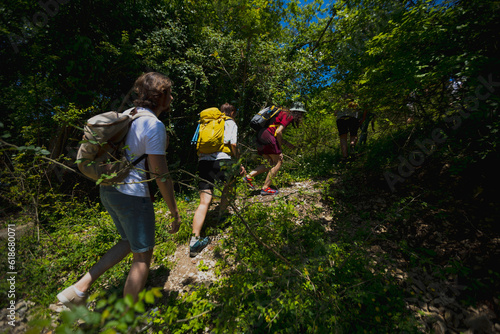 Group of backpackers climbing hill in woods