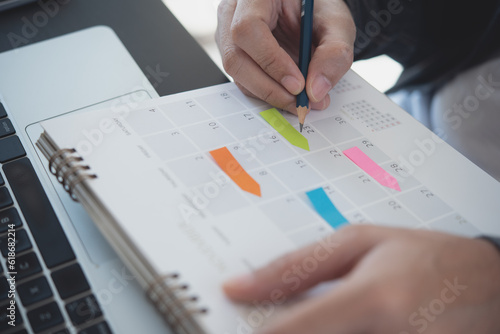 2024 Calendar event planning timetable agenda plan on organize schedule. Event planner agenda organizing by organizer schedule. Business man hand note on notebook with calendar planner on office table photo
