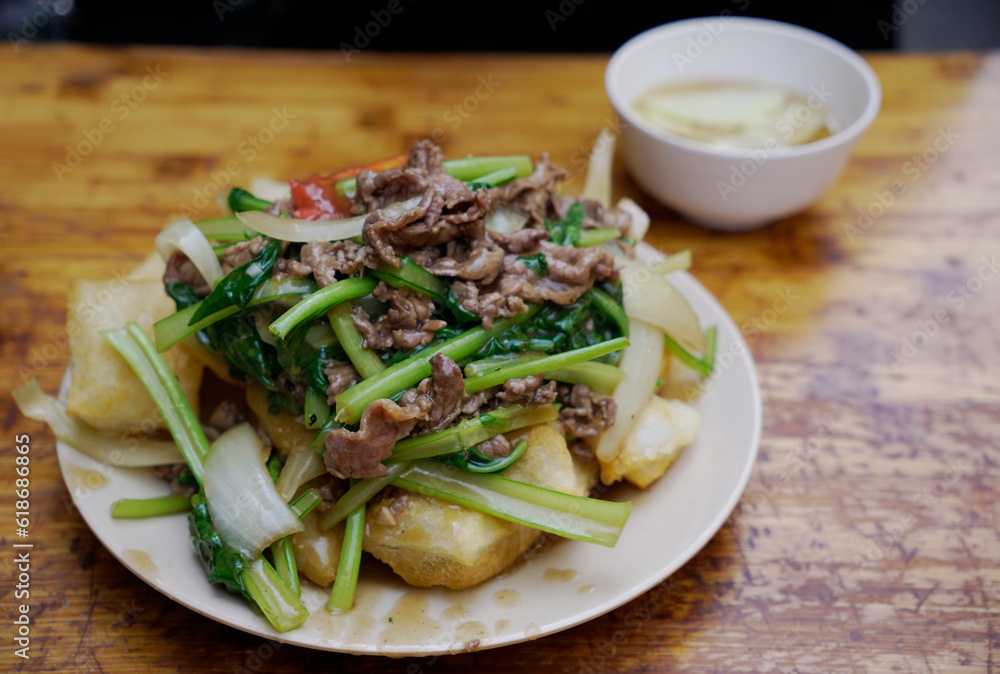 Delicious plate of Hanoi’s signature Fried Pho with beef and veggies